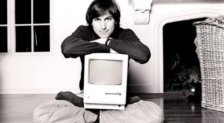 Стив Джобс с компьютером Apple на коленях