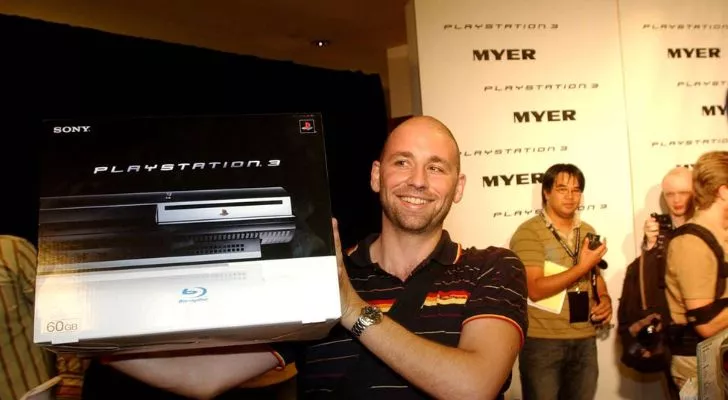 Человек держит коробку с PlayStation 3.