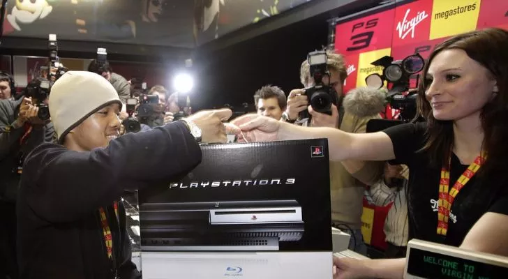Мужчину фотографируют, когда он получает свою PS3.