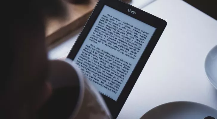 Кто-то читает с помощью электронной книги Amazon Kindle
